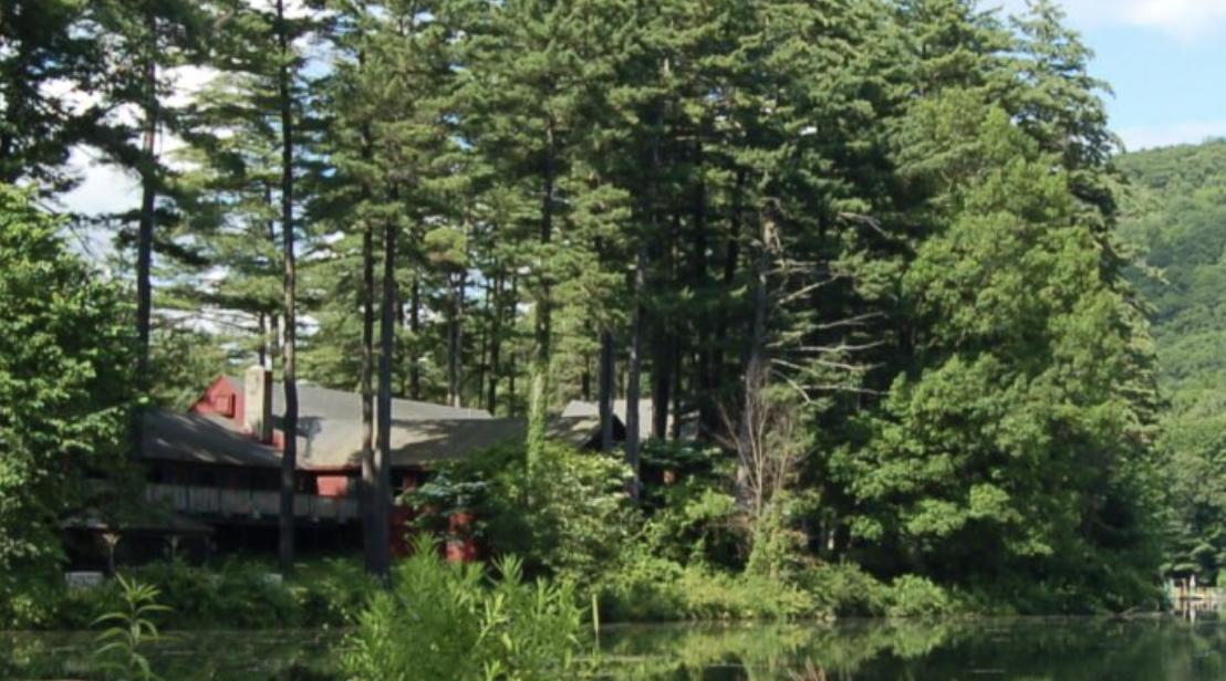 image of green woods with a building nestled in the trees